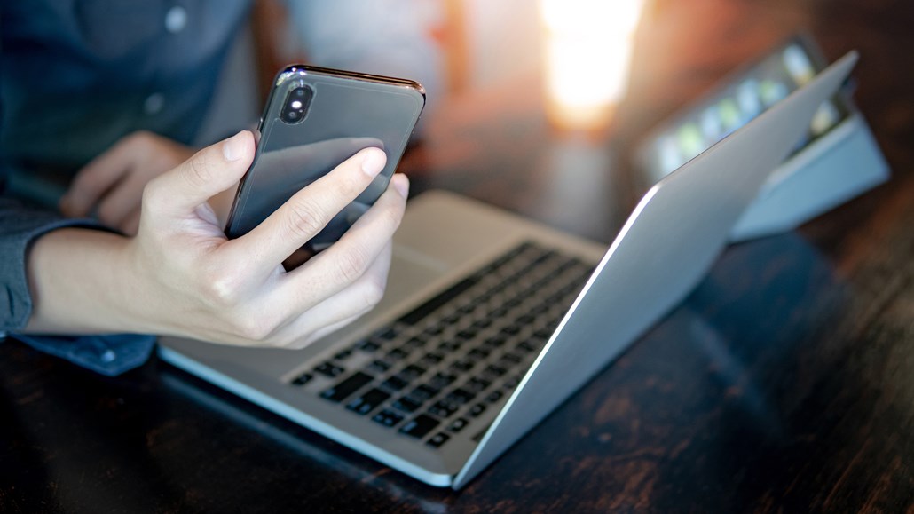 有手机和笔记本电脑的男人